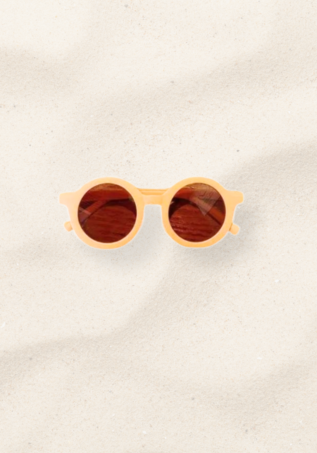 Neutral apricot beige toddler sunglasses with round dark lenses and soft curved arms.