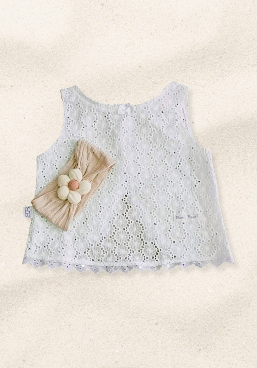 Oat-colored toddler head band with a cream daisy flower sewn at the center.