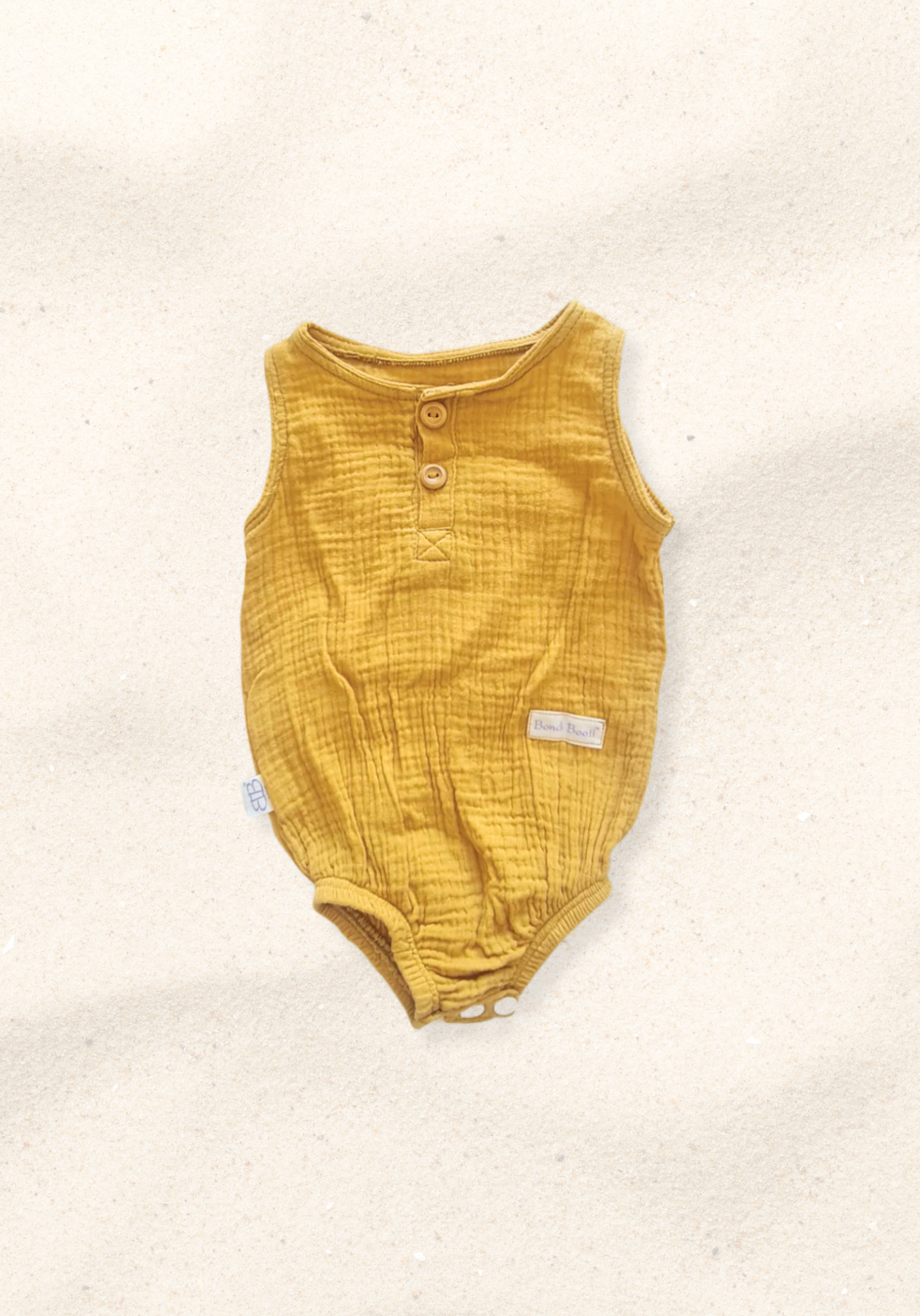 Mustard short sleeve organic cotton baby romper with three snap buttons at the bottom and elasticised leg bands