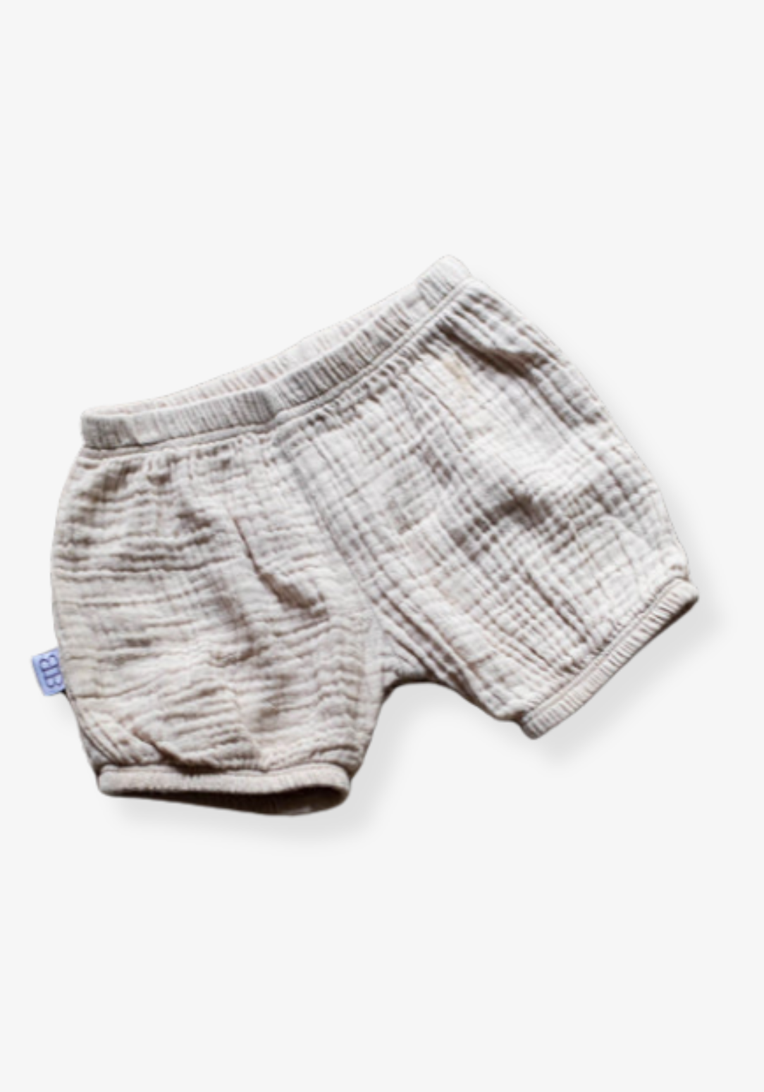 Three-pack of organic cotton baby bloomers in assorted neutral tones with elastic waist and leg openings
