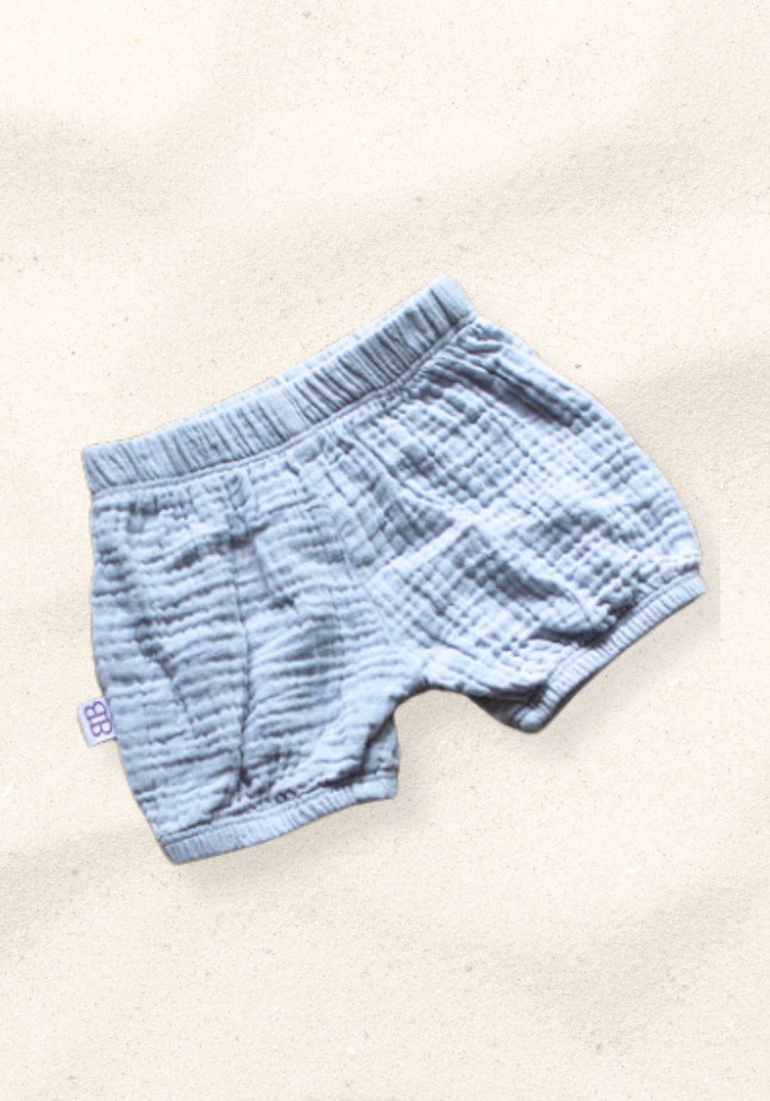 Three-pack of organic cotton baby bloomers in assorted neutral tones with elastic waist and leg openings