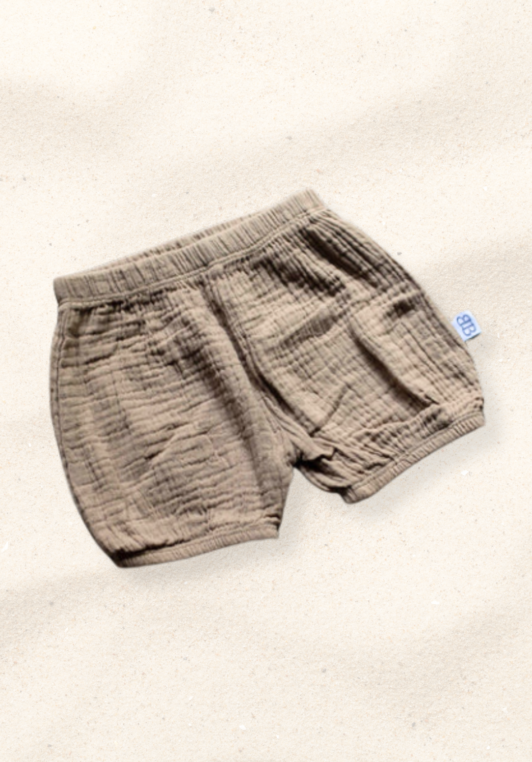 Three-pack of organic cotton baby bloomers in assorted neutral tones with elastic waist and leg openings