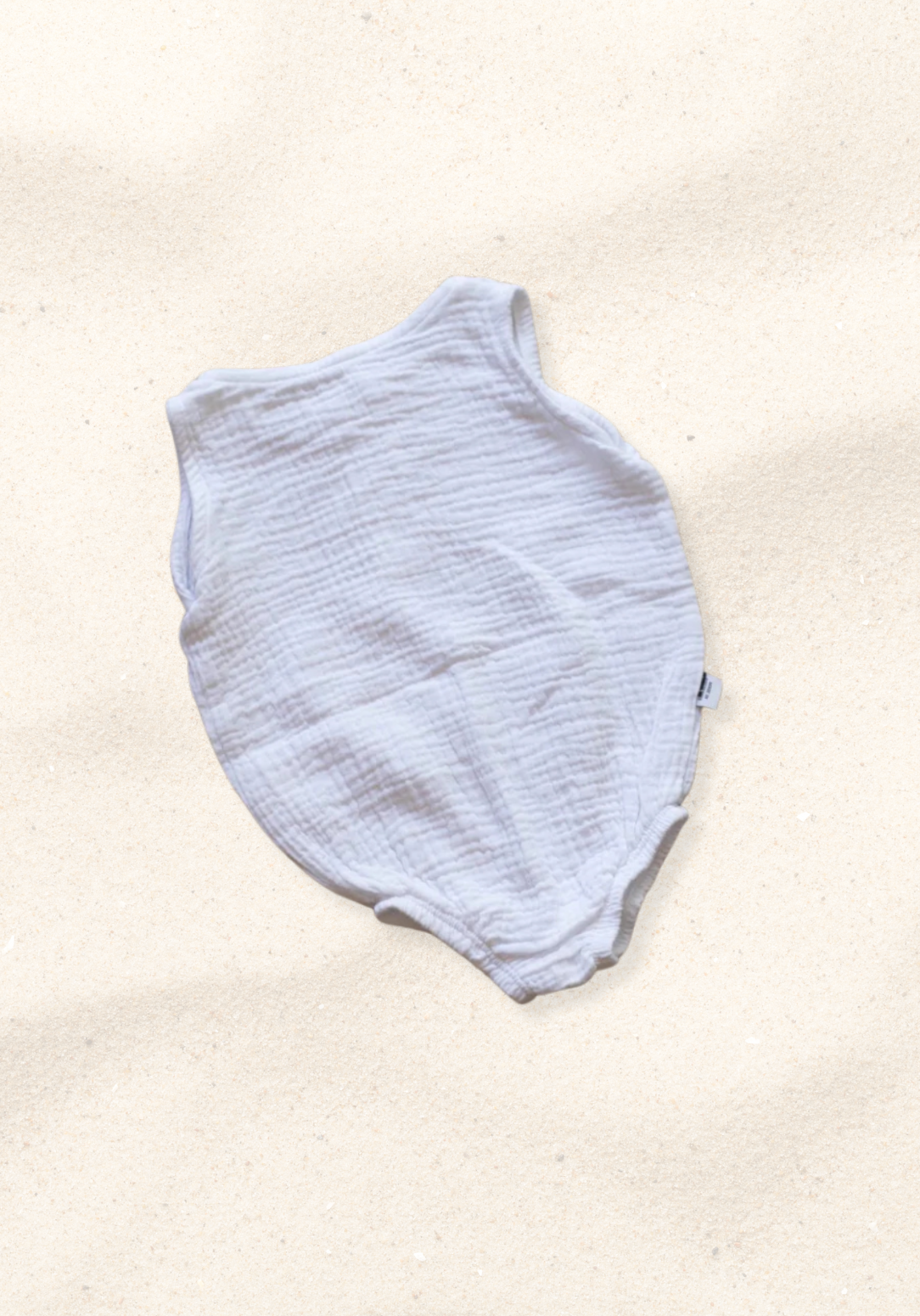 White organic cotton baby romper with three snap buttons and elasticised leg bands