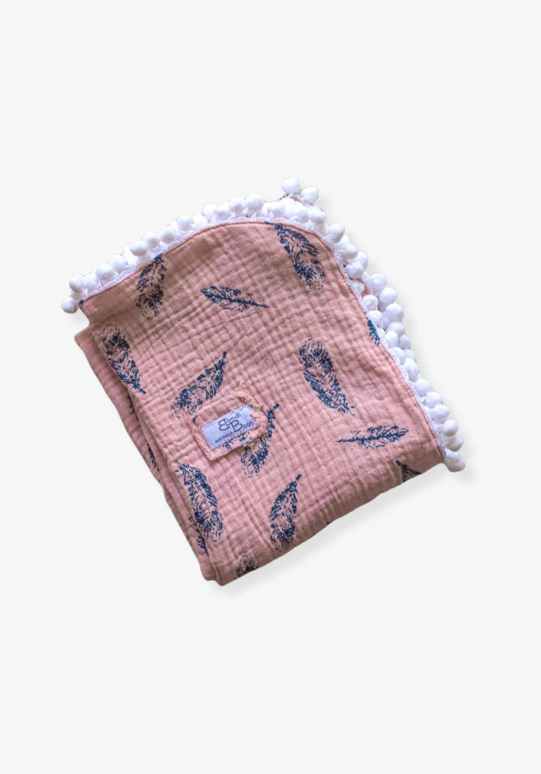 Dusty pink organic cotton baby blanket with navy feather print and white pom-pom trim, folded neatly with a visible Bondi Booti label.