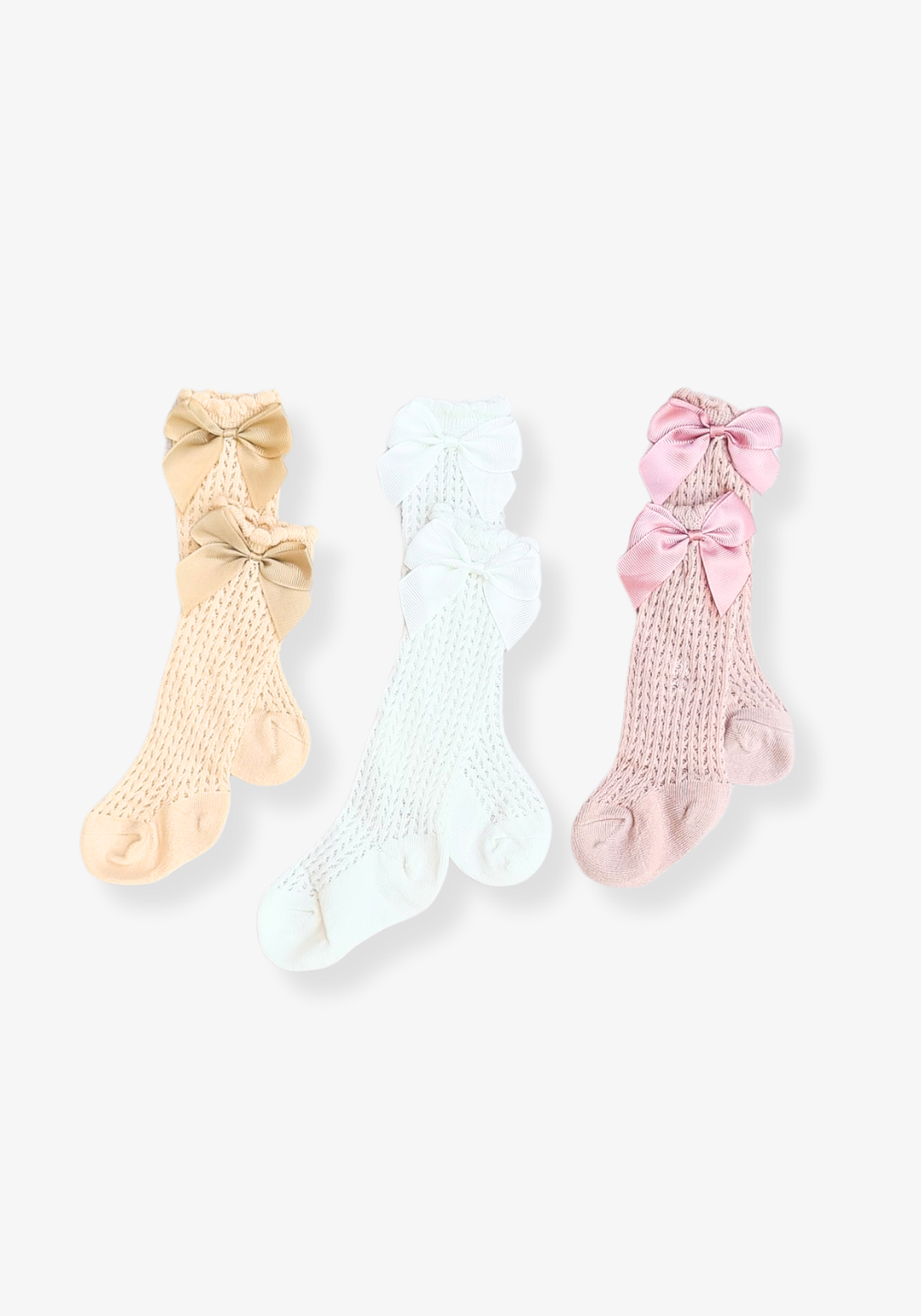 Set of three baby girl knee-high socks in beige, white, and pink with large decorative bows