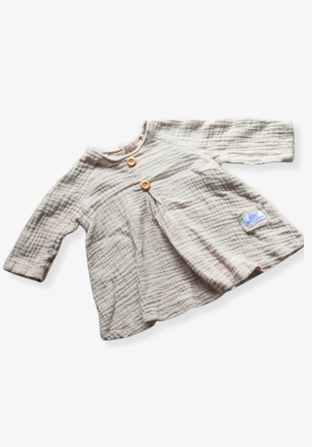 Boho-style baby dress in beige with embroidered hem, made from breathable cotton and displayed on a neutral grey background