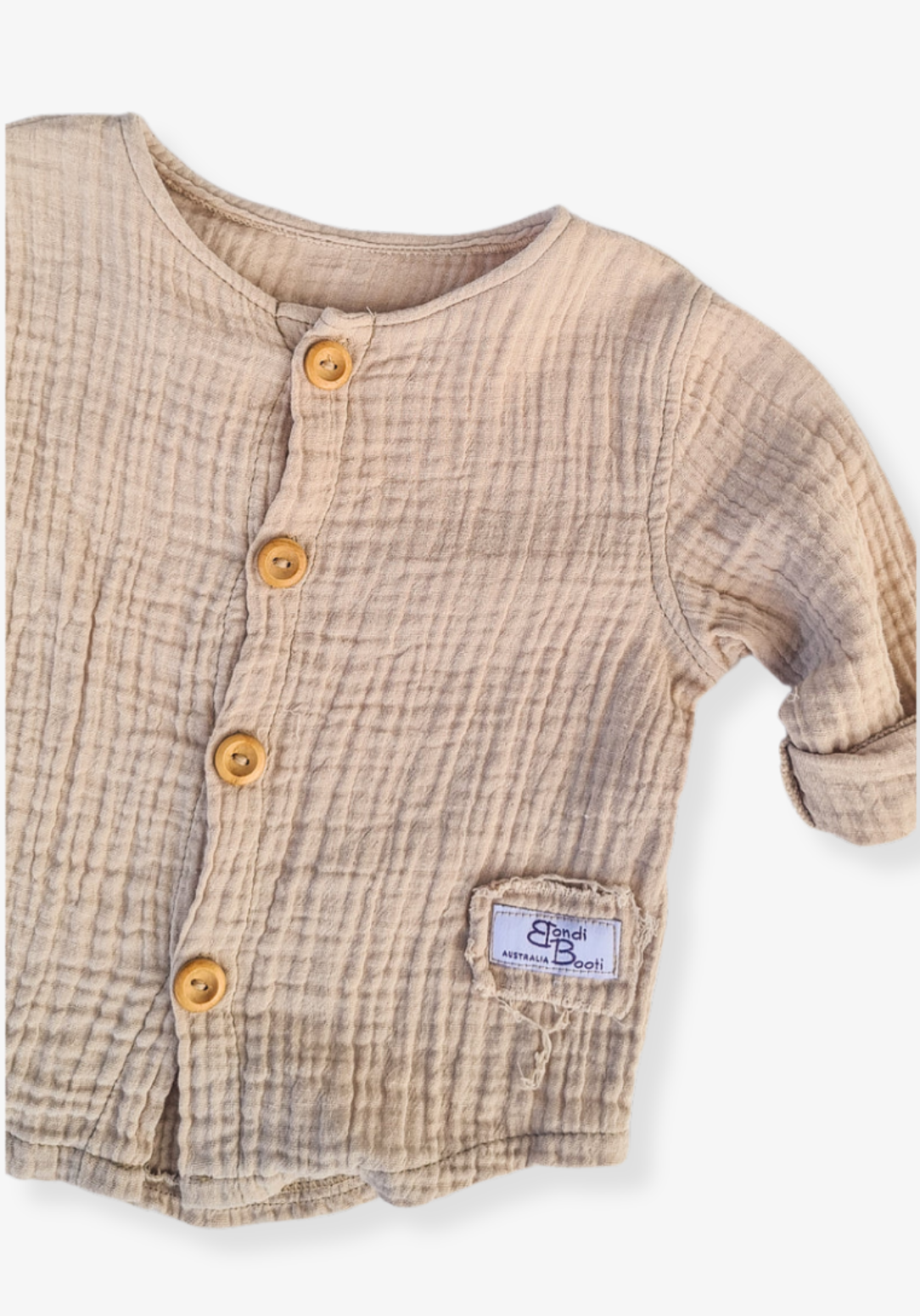Beige organic cotton island-style shirt for babies and toddlers, featuring front wooden buttons and rolled sleeves