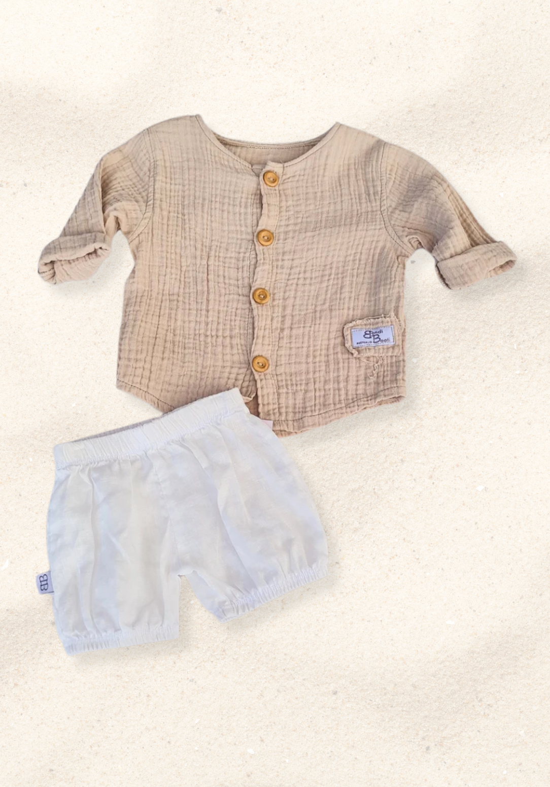 Beige organic cotton island-style shirt for babies and toddlers, featuring front wooden buttons and rolled sleeves