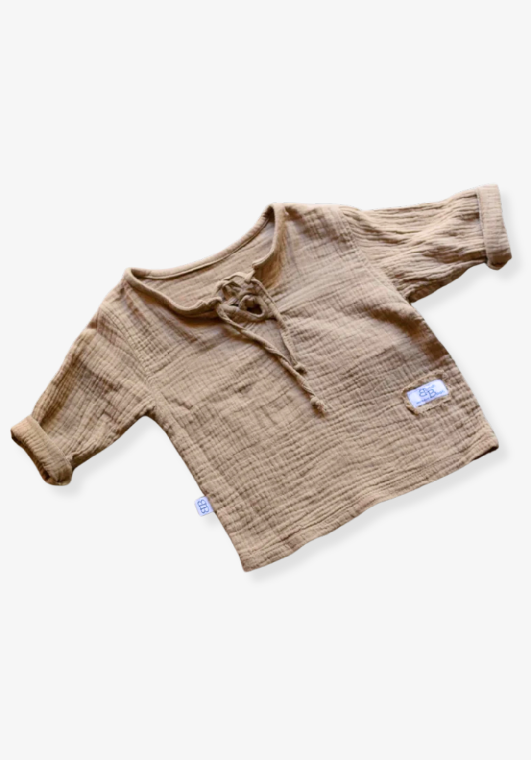 Mocha baby shirt in pirate style with soft cotton muslin fabric and wooden button details, displayed on a grey background