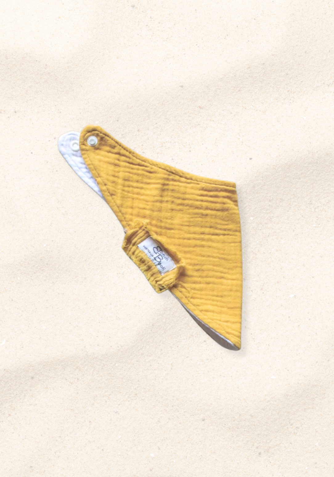 Mustard yellow organic cotton baby bandana dribble bib with soft fabric and snap closure.