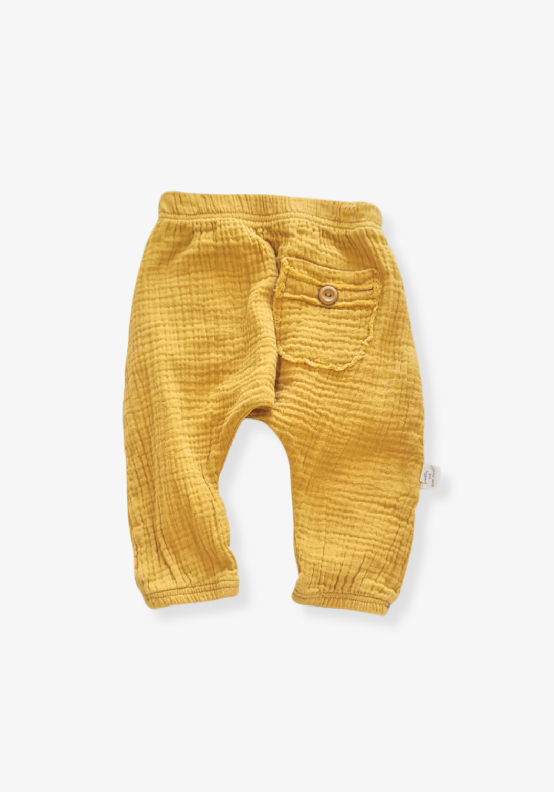 Toddler harem pants in mustard yellow made from organic cotton with a wooden button and soft elastic waistband