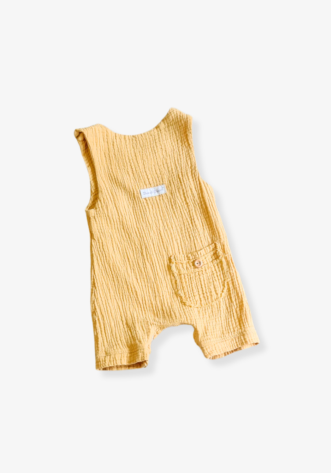 Mustard-colored organic cotton baby overall onesie with easy-change snaps on the bottom and wooden buttons on the shoulders.