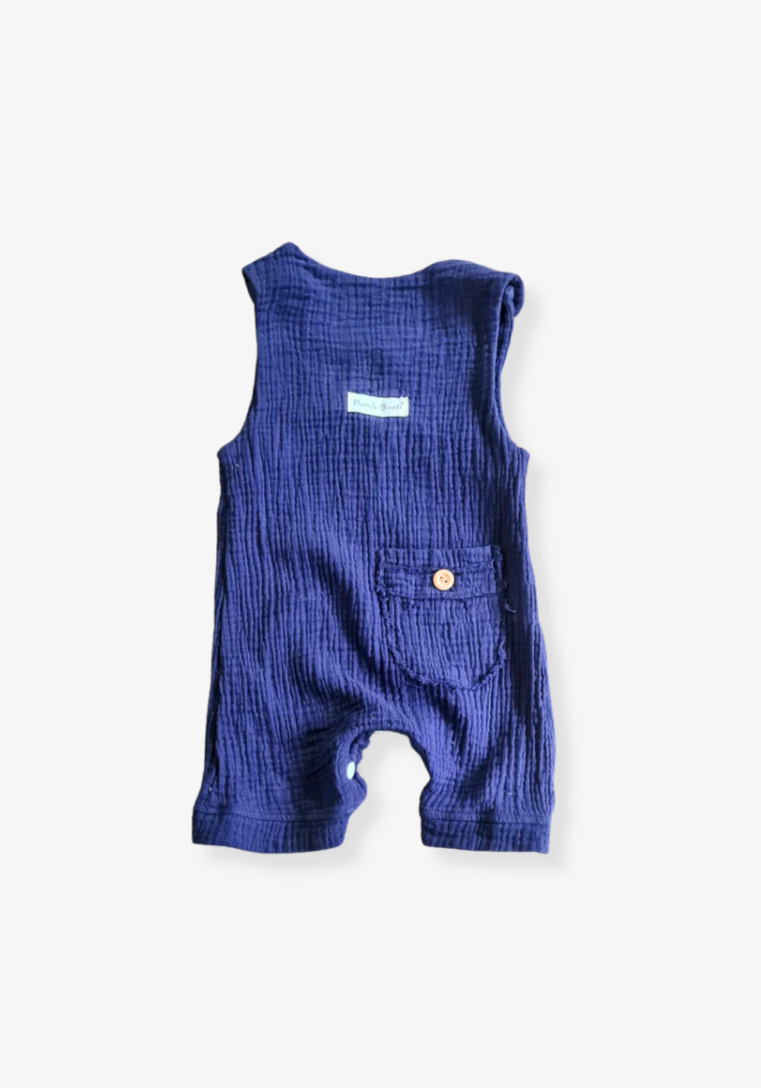 Navy organic cotton baby overall onesie complete with crotch snaps and wooden buttons, displayed on a neutral grey background