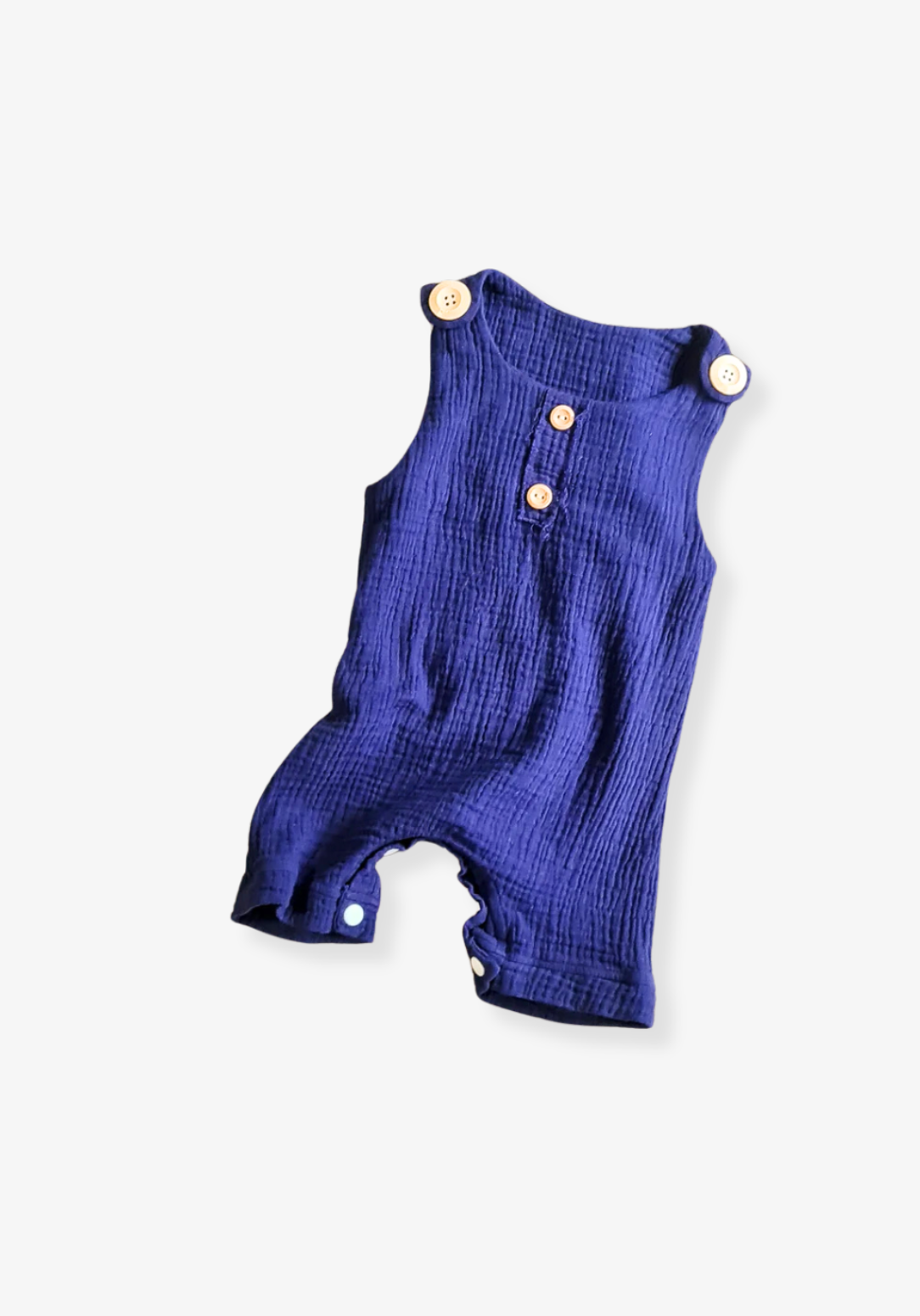 Navy organic cotton baby overall onesie complete with crotch snaps and wooden buttons, displayed on a neutral grey background