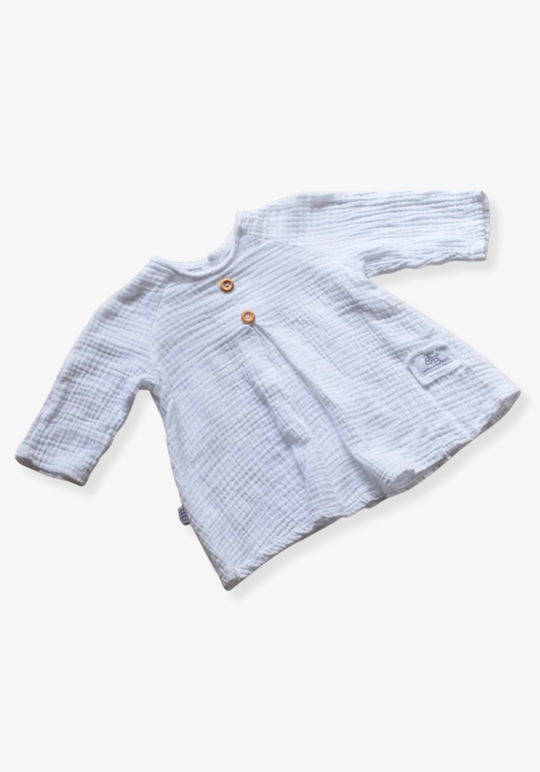 White cotton boho baby dress with elegant lace embroidery displayed on a soft grey background