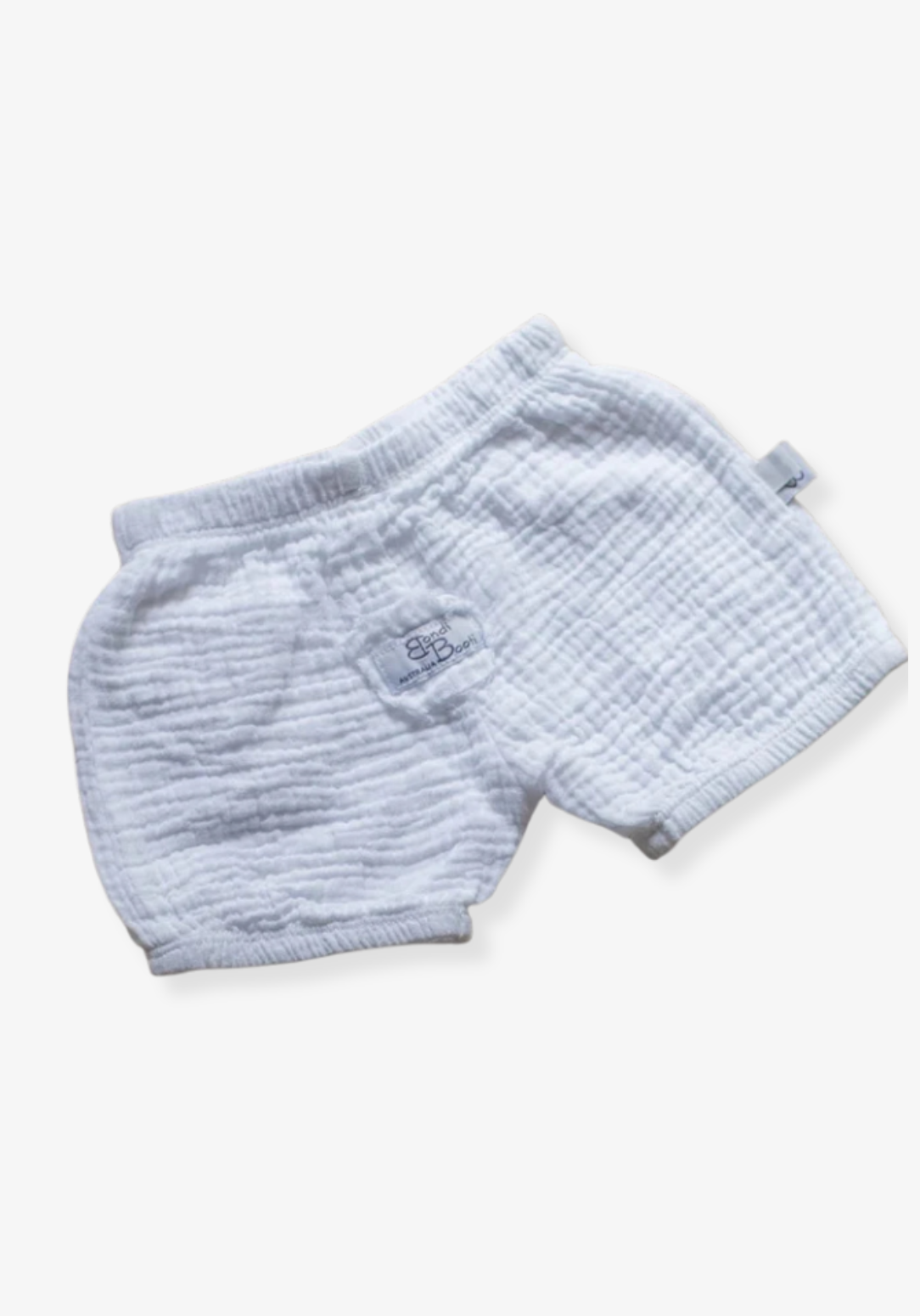 Minimalist white baby bloomers made from breathable organic cotton, displayed on a grey background with elastic details