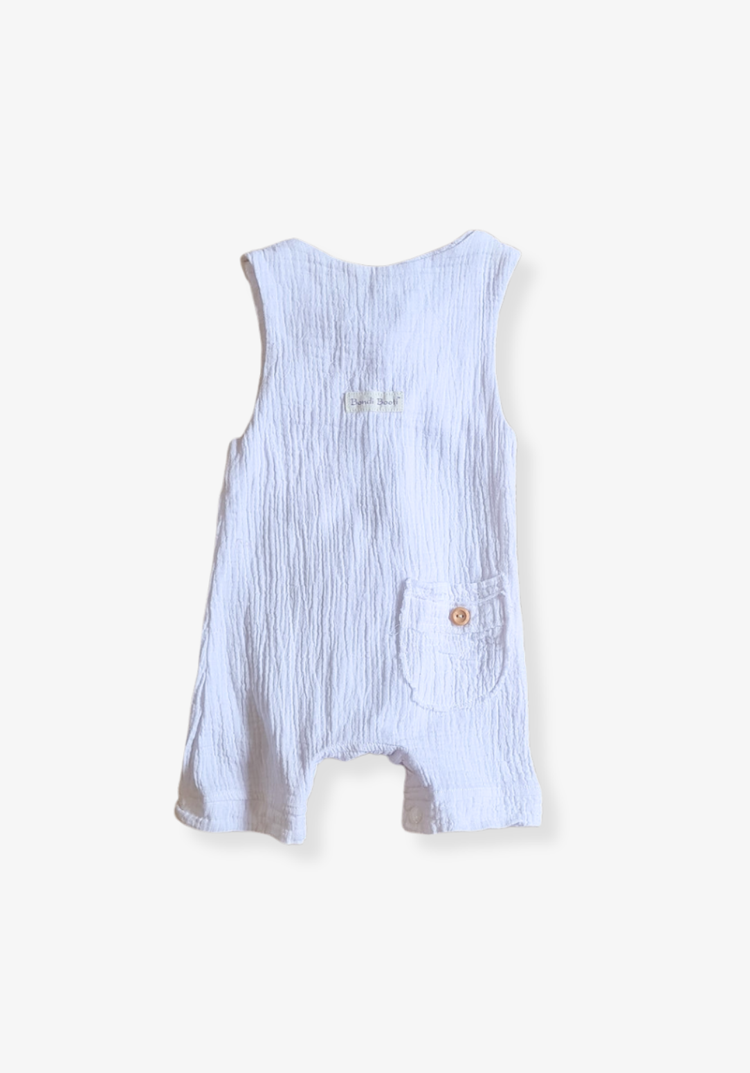 White baby overall onesie made from breathable organic cotton with wooden buttons and crotch snaps.
